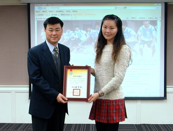 李佳倫組長代表本校接受體育司王俊權司長（左）頒發健康促進績優學校獎狀 - 