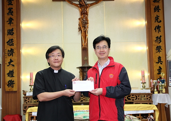  王育文董事长代表本校致赠爱心捐款给圣方济育幼院，  并由该院创办人杨安仁神父(左)代表接受 - 