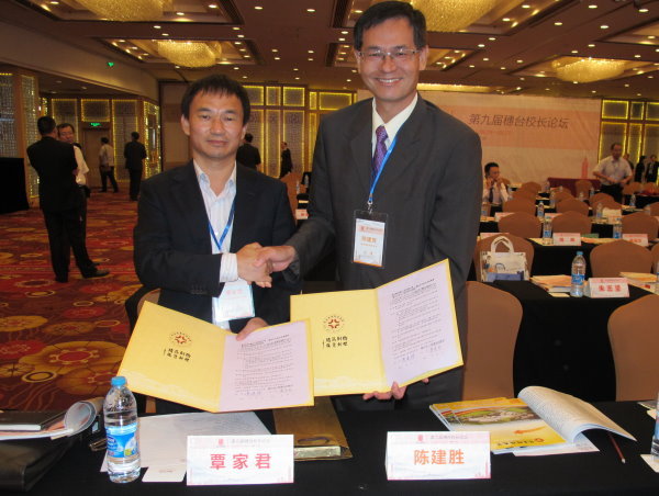 陈建胜校长（右）与覃家君副校长（左）代表两校签订协议后合影 - 