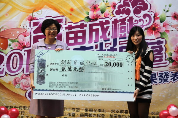兼具校友及廠商身分的張雅婷(圖右)捐出兩萬元回饋金，由李副校長代表收下 - 