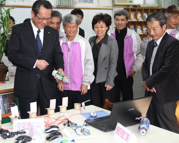名古屋產大伊藤雅一校長(左一)所動手體驗的「空氣槍」遊戲，使用的素材都是資源回收物 - 