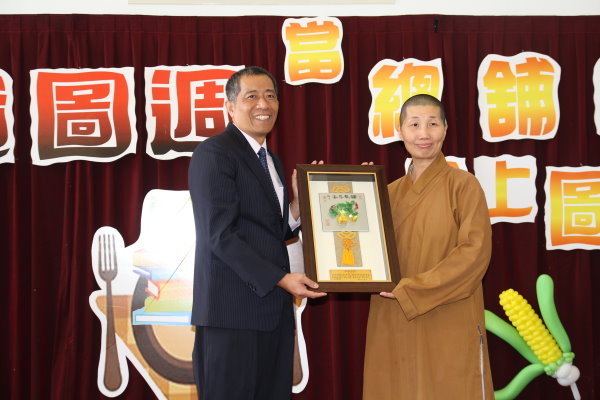 王資圖長(左)送上感謝牌給安排捐書事誼的佛光山宏法寺社滿尚法師(右) - 